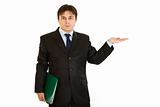 Serious  businessman with folder presenting something on empty hand
