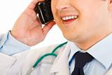 Smiling medical doctor talking on mobile phone. Close-up.
