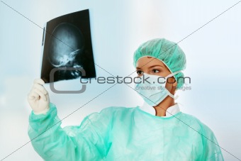Female doctor examining a head x-ray photo scan