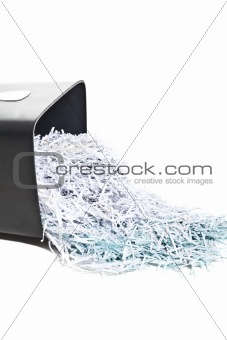 trash can overturned with shredded paper