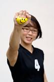 Asian female sporty lady squeezing yellow happy ball