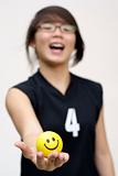 Excited asian lady holding yellow happy ball in hand