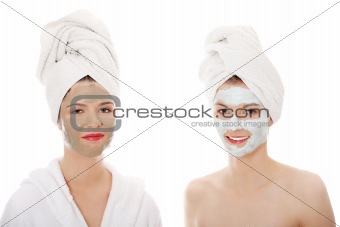 Young happy women with facial clay mask 