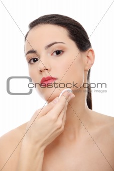 Young beautiful caucasian woman using a cotton pad