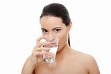 Beautiful young woman drinks clear mineral water