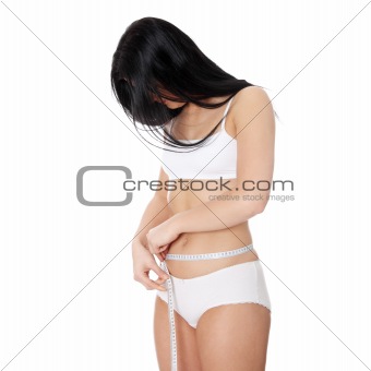 Sexy, young woman measuring her waist