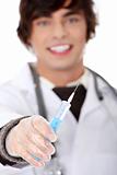 Handsome young doctor holding syringe