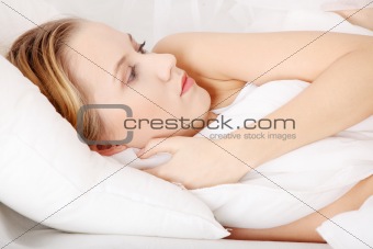 Sad woman lying in bed
