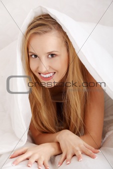 Beautiful young happy caucasian woman in bed