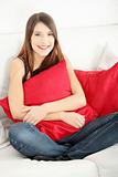 Young happy woman sitting on sofa