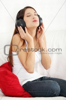 Young beautiful woman at home listening music 