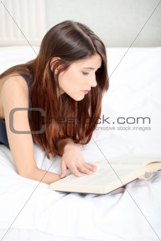Woman reading a book on the bed