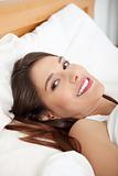 Portrait of beautiful smiling woman on bed