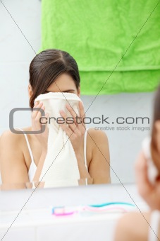 Beautiful woman wipes her face with a towel