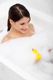 Woman taking a bath with yellow duck.