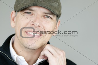 Smiling Man In Newsboy Hat Adjusts Collar
