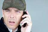 Worried Man In Newsboy Hat On Phone