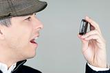 Man In Newsboy Hat Looks At Cell Phone In Amazement