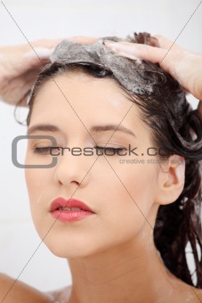 Beautiful young woman washing her hairs