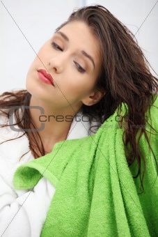 Beautiful young woman wipes her hairs