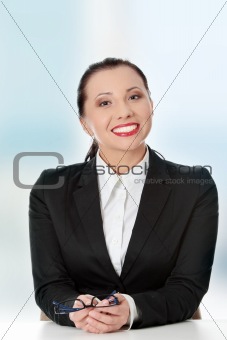 Young happy businesswoman behind the desk