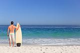 Man wirth his surfboard on the beach