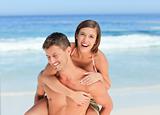 Man having wife a piggyback on the beach