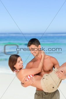 Man carrying his wife at the beach