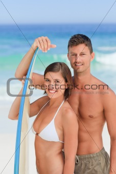 Lovers with their surfboard