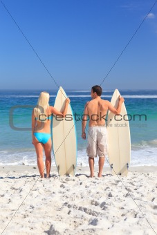 Lovers with their surfboards