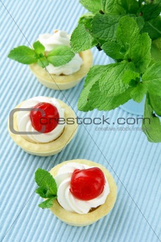 dessert tartlets with cream, mint and cherry