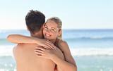 Woman hugging her boyfriend at the beach