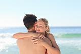 Woman hugging her boyfriend at the beach