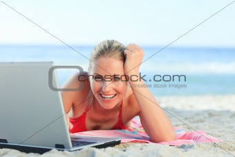 Lovely woman working on her laptop at the beach