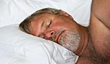 Senior man sleeping peacefully - intentional low light and shallow depth of field
