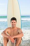 Handsome man with his surfboard at the beach