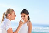 Mother applying sun cream on her daugter's nose