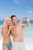Couple taking a photo of themselves on the beach