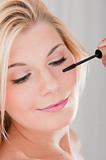 pretty woman applying her make-up mascara