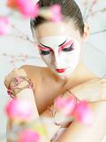 japan geisha woman with creative make-up in sakura garden