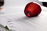 opened book and red apple