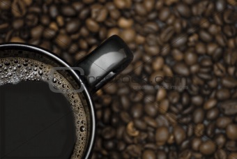 black mug of coffee and scattered beans