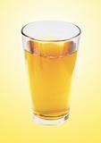 glass of apple juice over yellow background