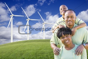Happy African American Family and Wind Turbine with Dramatic Sky and Clouds.