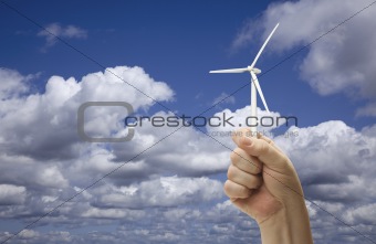 Male Fist Holding Wind Turbine Outside with Clouds and Sky.