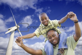 Happy African American Father and Son with Wind Turbine Over Blue Sky.