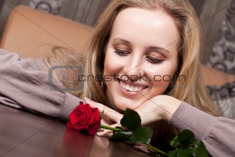 Young smiling girl with a red rose