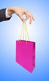 woman hand holding colorful shopping bag over blue background