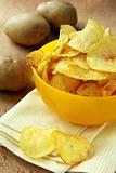 potato chips in a yellow cup, and fresh potato