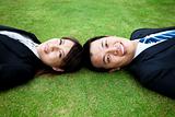 Attractive young adult couple and lay on the grass field